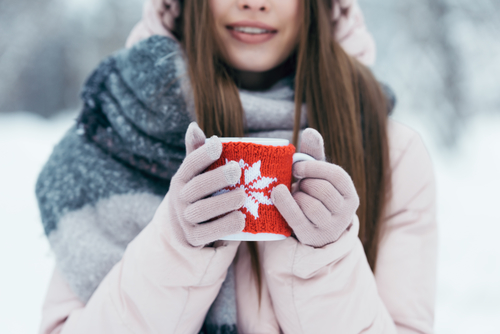 woman outside during winter holding a mug