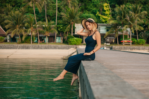 woman sitting close to water on tropical vacation