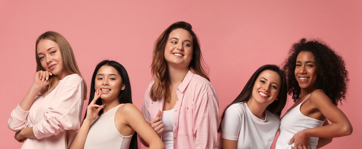 Group of women with different body types and ethnicities in underwear on pink background