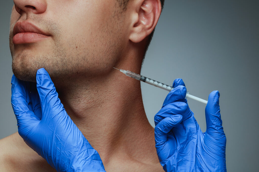 Young man getting anti-aging dermal filler injection. 